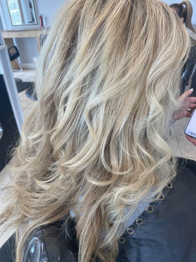 Back view of bright blonde hair with soft layered waves