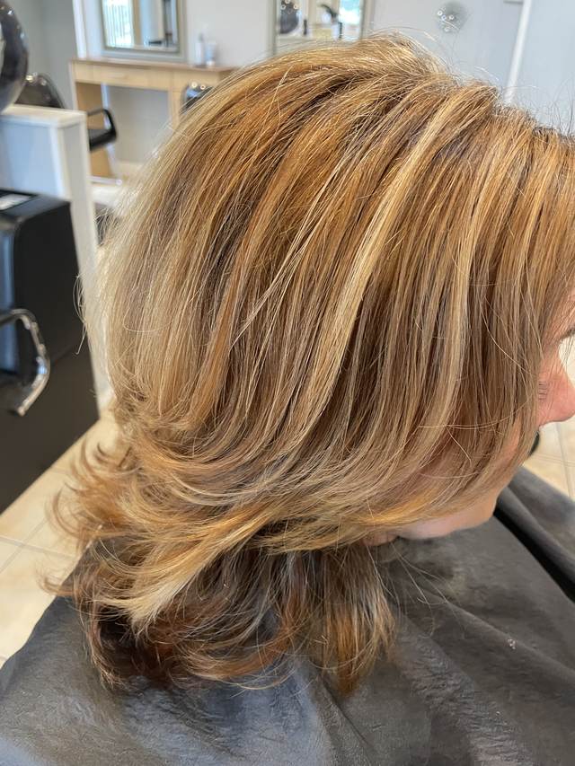 Honey blonde highlights on a layered shoulder-length cut